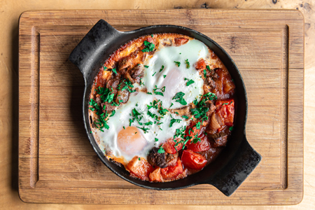 Free photo closeup of traditional shakshuka in a frying pan on a wooden background